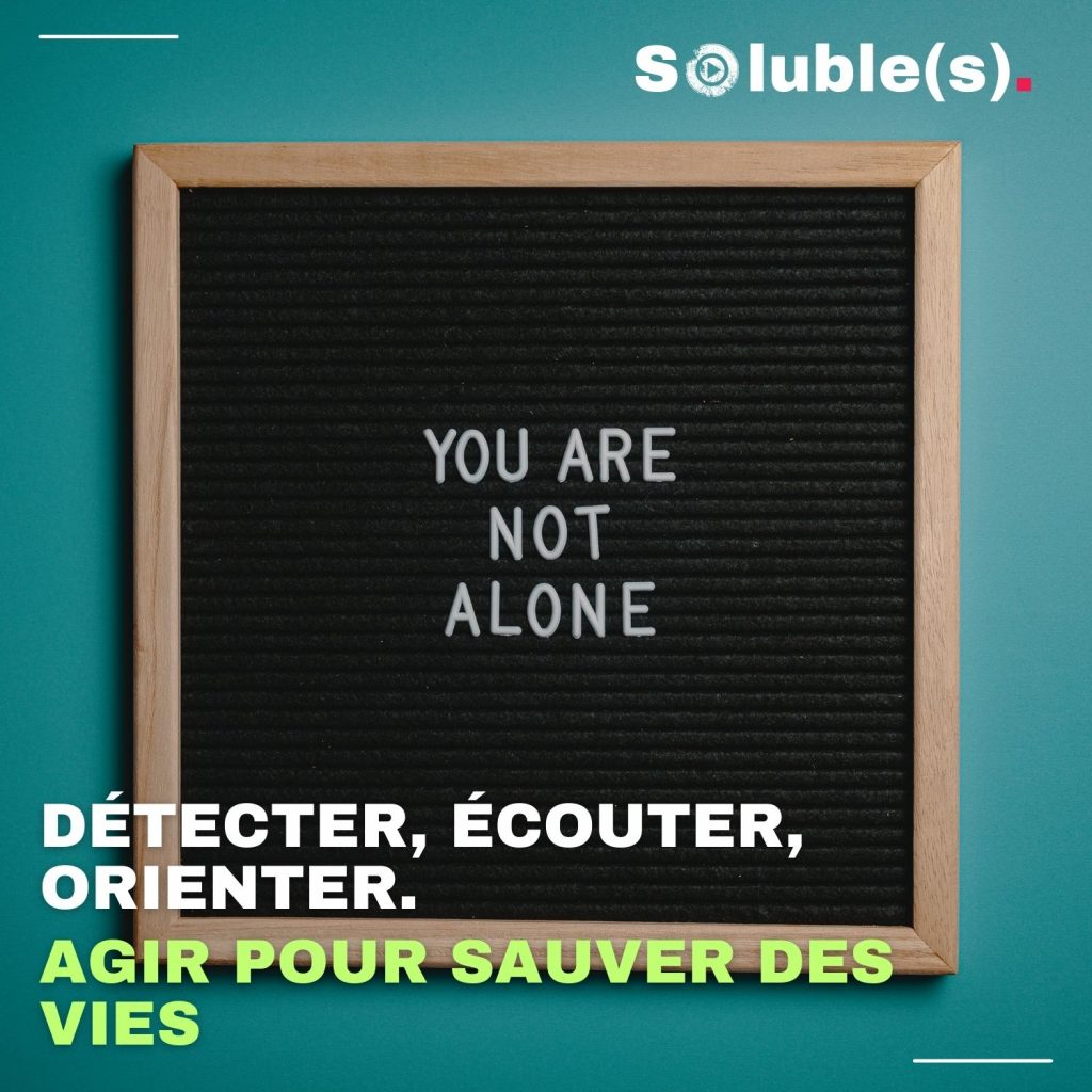 Un tableau noir à lettres à poser représente la phrase anglaise : "You are not alone". Texte sur l'image : AGIR POUR SAUVER DES VIES DÉTECTER, ÉCOUTER, ORIENTER.