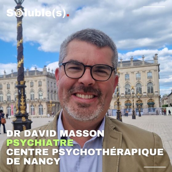 Portrait du Docteur David Masson pris place Stanislas à Nancy. Il est sourriant, porte une barbe, des lunettes et des cheveux légèrement grisonnants. Texte dans l'image : DR DAVID MASSON PSYCHIATRE CENTRE PSYCHOTHÉRAPIQUE DE NANCY