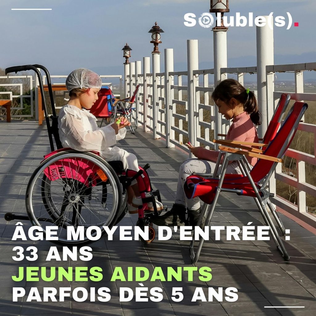 Deux petites filles jouent assises dehors sans doute sur une promenade de bord de mer/A gauche, la petite fille est en fauteuil roulant , elle porte sur la tête une charlotte d'hôpital. à Droite, la seconde petite fille lui fait face.Texte : ÂGE MOYEN D'ENTRÉE : 33 ANS JEUNES AIDANTS PARFOIS DÈS 5 ANS