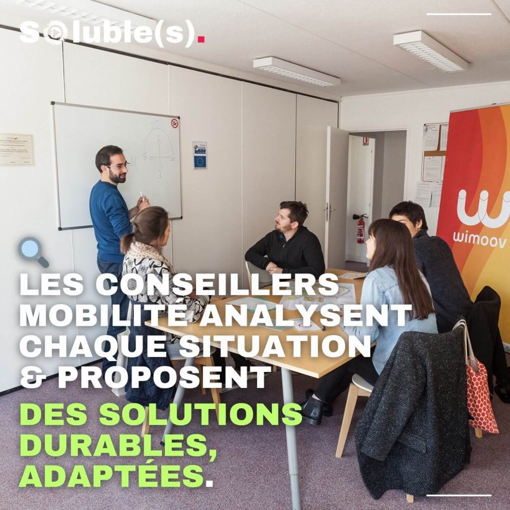 Conseiller explique au tableau dans un bureau Wimoov. Texte à lire : "Les conseillers mobilité analysent chaque situation & proposent des solutions durables, adaptées."