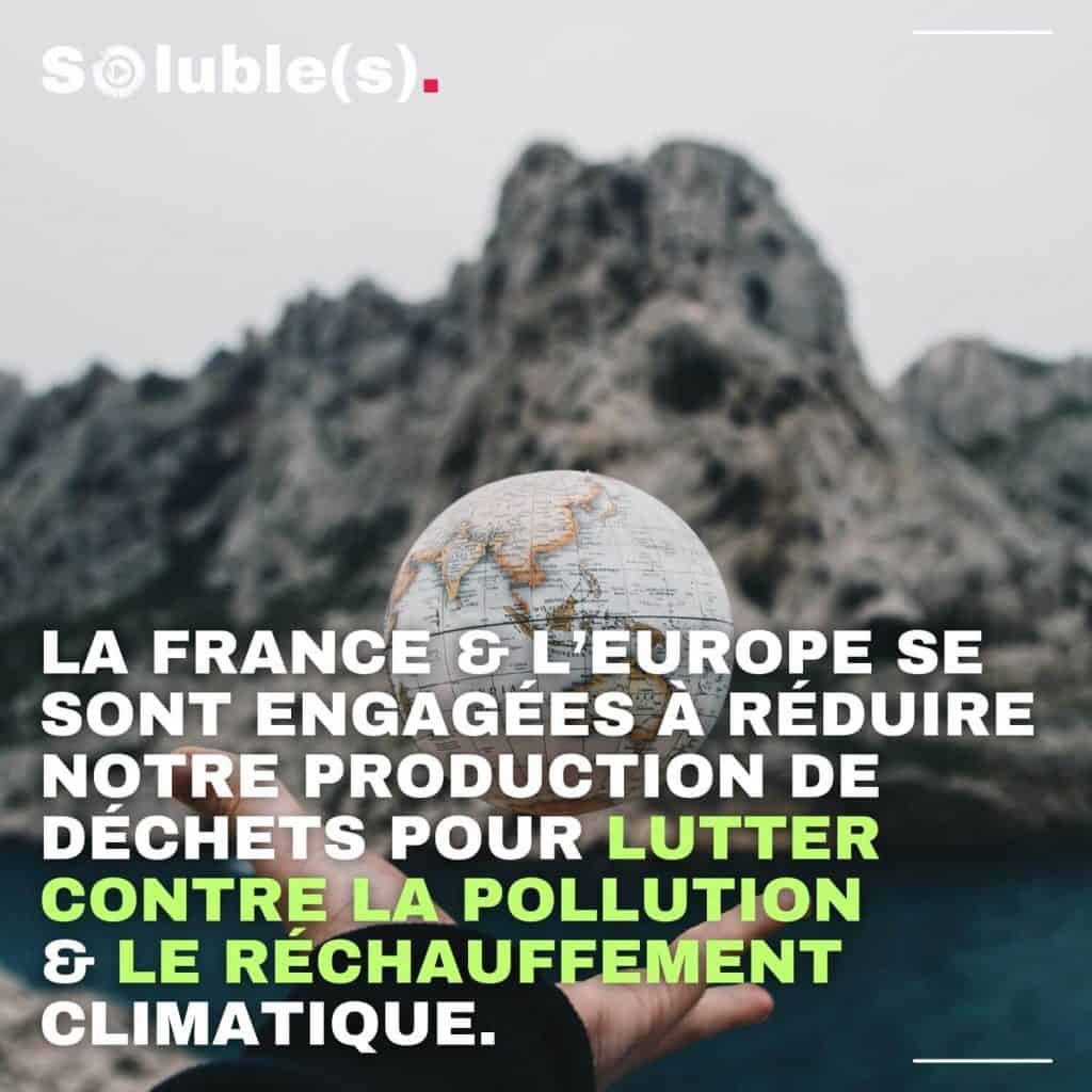 Une main ouverte tenant un petit globe terrestre sur un fond flou de rochers. Texte : La France & l'Europe se sont engagées à réduire notre production de déchets pour lutter contre la pollution & le réchauffement climatique.