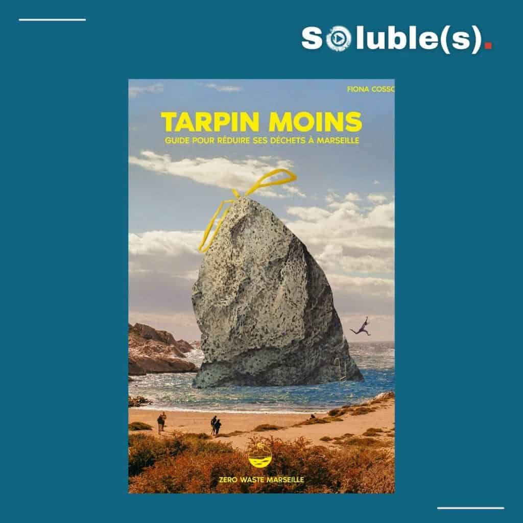 Couverture du livre présentée sur un fond bleu canard avec le logo Soluble(s). Titre : 'TARPIN MOINS GUIDE POUR RÉDUIRE SES DÉCHETS À MARSEILLE'. L'illustration représente un rocher en bord de mer fermé comme un sac poubelle par un lien jaune. En bas : Zero Waste Marseille