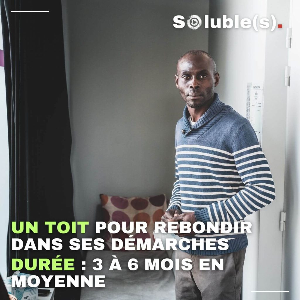 Portrait d'un homme en pull rayé bleu et blanc debout dans une chambre d'hébergement d'urgence, avec le texte "Un toit pour rebondir dans ses démarches : durée 3 à 6 mois en moyenne".