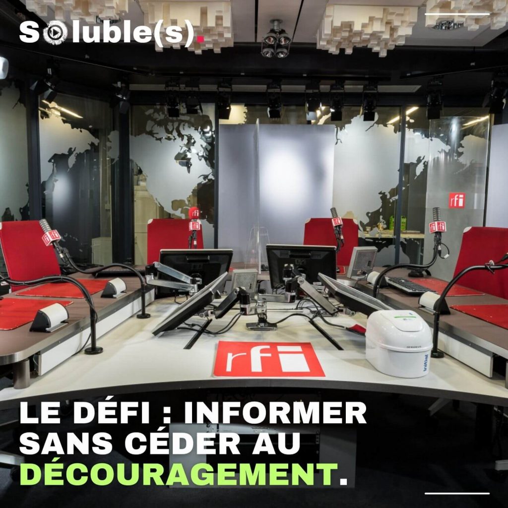 Visuel Soluble(s) montrant le studio de radio de RFI vide, avec plusieurs micros et écrans, et le texte : “Le défi : informer sans céder au découragement.”